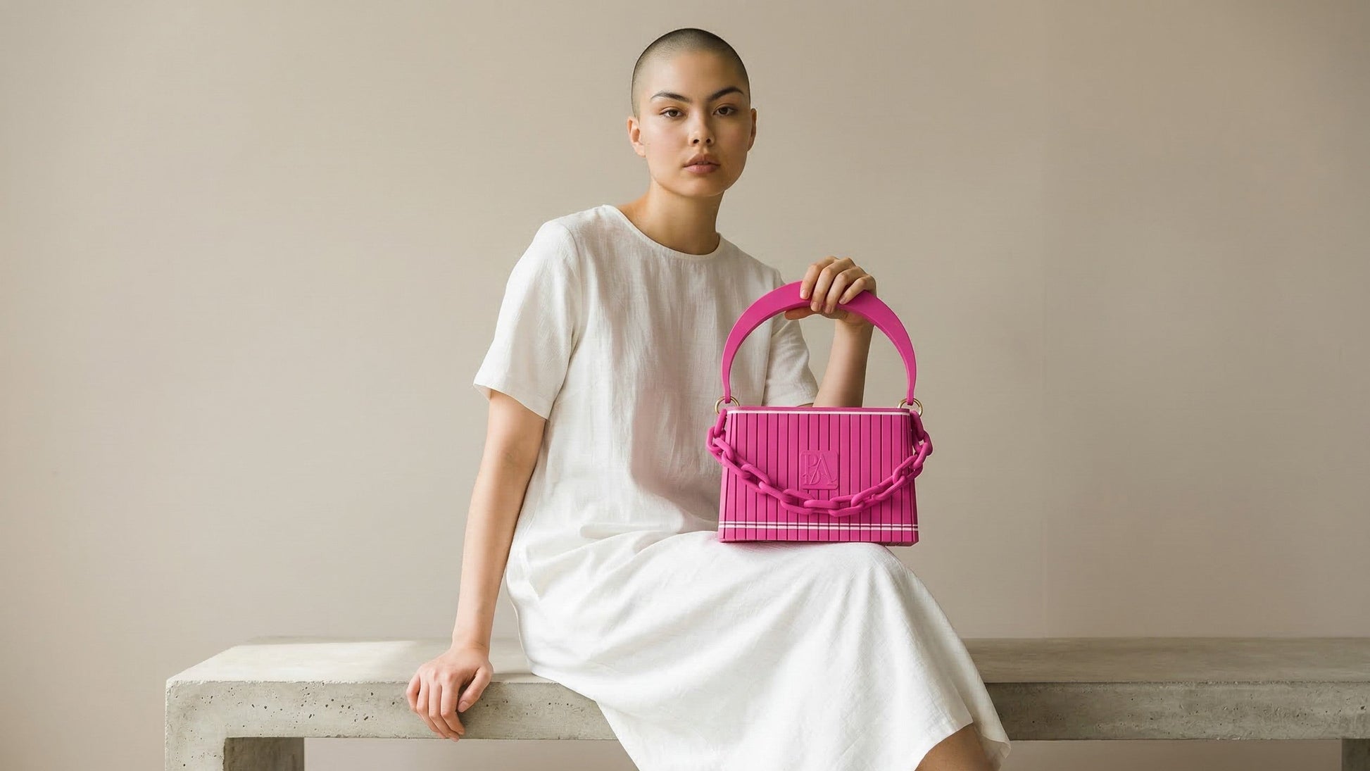 HAKO Handtasche in Fuchsia mit Ketten-Detail, getragen von Model im minimalistischen Studio mit neutralem Hintergrund