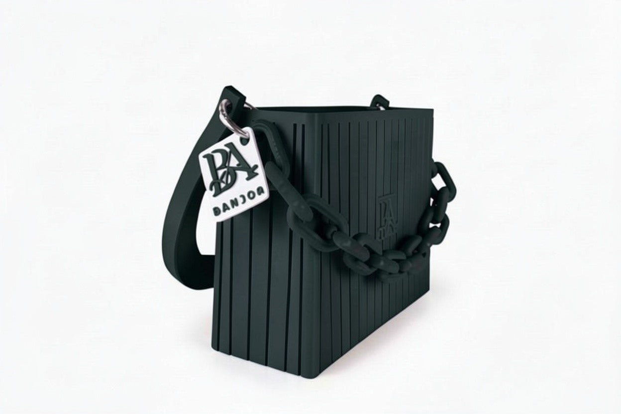 HAKO Handtasche in Schwarz, Seitenansicht mit strukturierter Oberfläche, Ketten-Detail und BANJOR Anhänger, Designer-Tasche